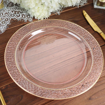 Elegant clear glass plate with textured rim and gold trim on wooden table.
