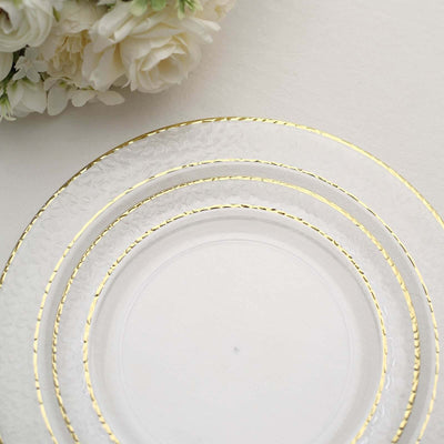 Clear glass plates with gold trim, elegantly arranged.