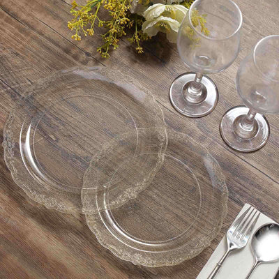 Clear glass plates and wine glasses on a wooden table setting.