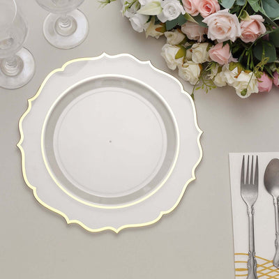 Elegant white plate with gold rim, surrounded by flowers and cutlery.