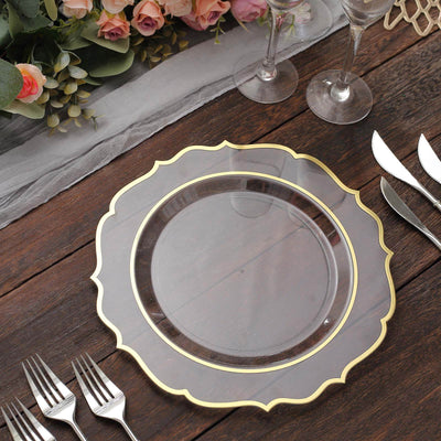 Elegant gold-trimmed clear charger plate on a wooden table setting.