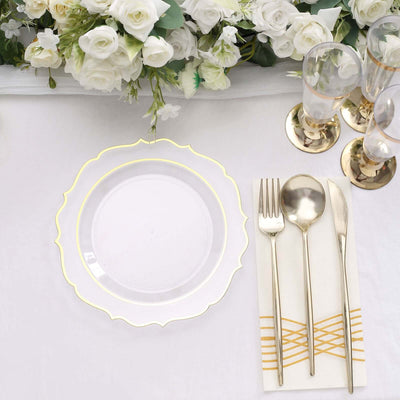 Elegant clear plate with gold trim set on a pristine table with floral arrangement.