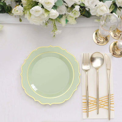Mint green plate with gold trim beside silver cutlery on a table setting.