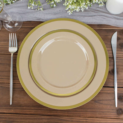 Elegant beige dinner plates with gold trim on a rustic wooden table setting.