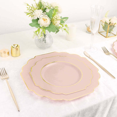 Elegant pink plates with gold trim set on a dining table with floral centerpiece.