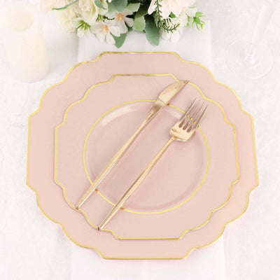Elegant pink dinner plate with gold trim, fork, and knife on a white table setting.