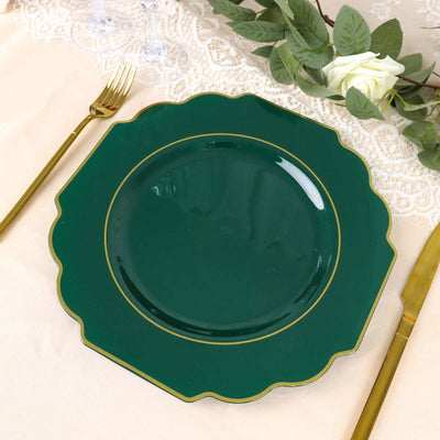 Green scalloped plate with gold trim on a table setting.