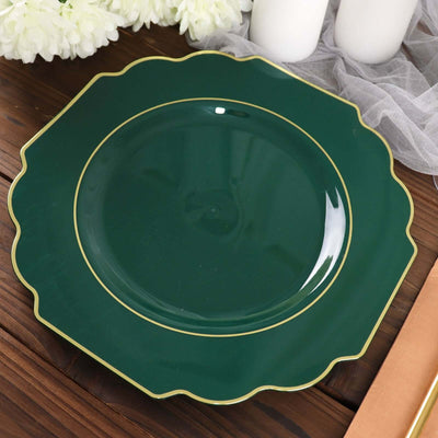 Green scalloped plate with gold trim on wooden surface.