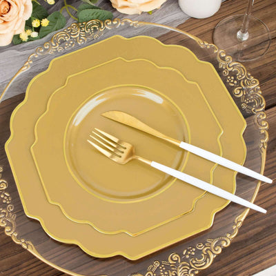 Gold decorative dinner plates with white cutlery on a wooden table.