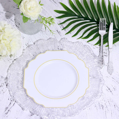 Elegant white plate with gold trim on a decorative clear glass charger.