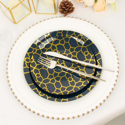 Elegant navy and gold geometric patterned dinner plates with silver utensils.