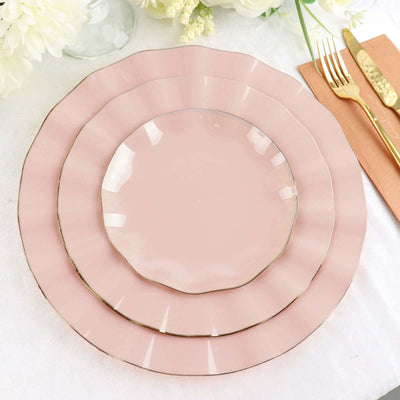 Elegant pink dinnerware set with gold rim accents on a soft background.