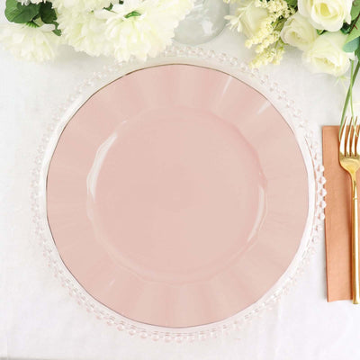 Pink glass charger plate with a decorative rim on a table setting.