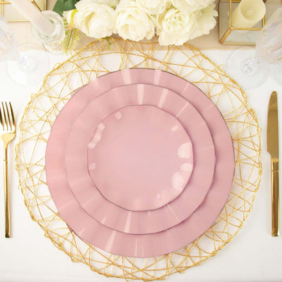 Elegant pink plates layered on a gold wire charger with floral decor.