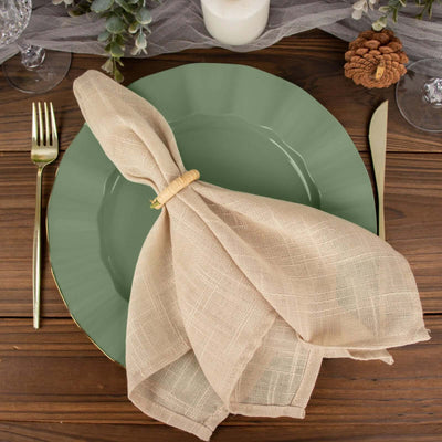 Green plate with linen napkin, fork, and knife on a wooden table setting.