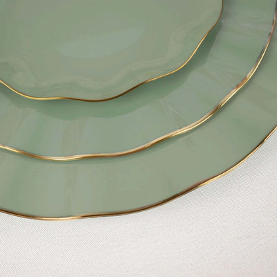 Green scalloped plates with gold edges stacked elegantly.
