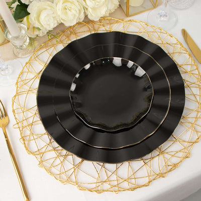Elegant black plate set on a decorative gold charger with floral backdrop.