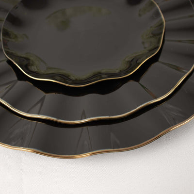 Elegant black plates with gold trim, stacked in a stylish arrangement.