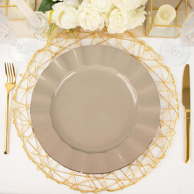 Elegant taupe dinner plate on a gold charger with cutlery and floral décor.