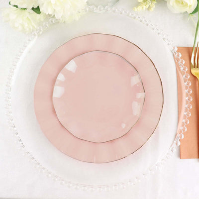 Elegant pink plates stacked on a clear charger for dining decor.