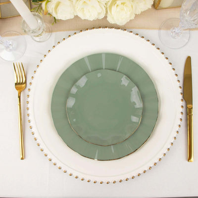 Elegant green and white dinner plate set with gold accents on a table setting.