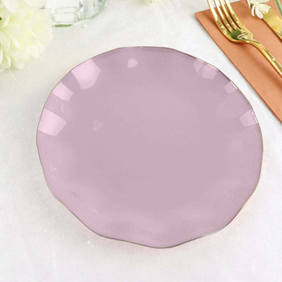 Purple scalloped plate on a textured surface with elegant cutlery.