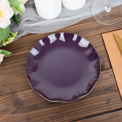 Purple scalloped plate on wooden table with flowers and candles.