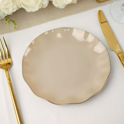 Elegant beige plate with gold trim, surrounded by gold cutlery.