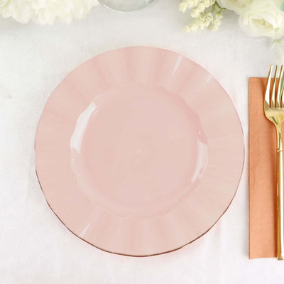Pink scalloped plate on a table setting with gold cutlery and napkin.