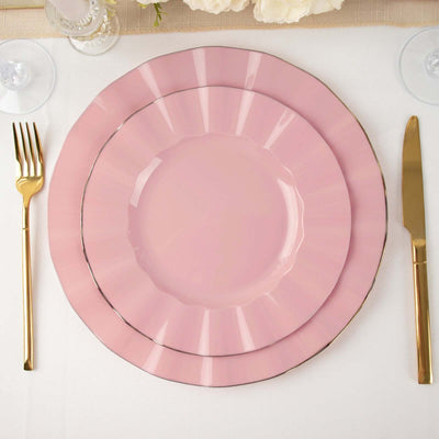 Pink decorative plates with gold trim, elegantly arranged with cutlery.