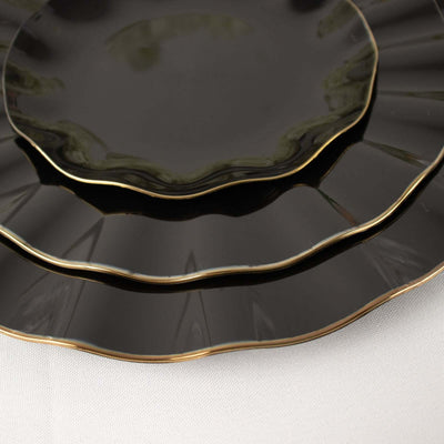 Black plates with gold rim in a stacked arrangement.