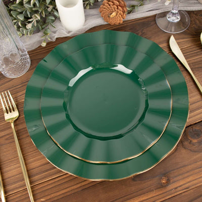 Green scalloped dinner plates stacked on a wooden table setting.