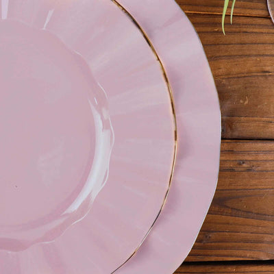 Elegant pink plates with gold trim on a wooden table.