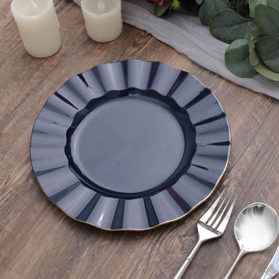 Elegant navy blue scalloped plate with gold trim on a rustic wooden table.