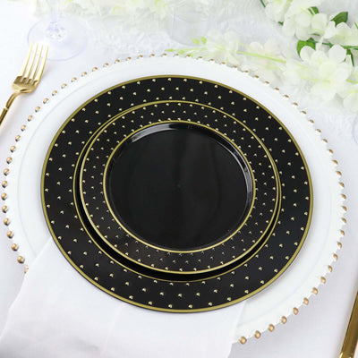 Elegant black and gold dinnerware set with three stacked plates on a table.