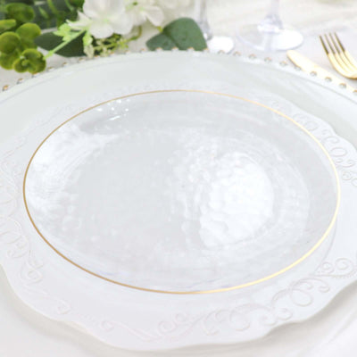 Elegant white plate with gold rim on decorative charger.