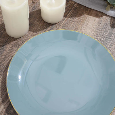 Light blue decorative plate with gold rim on wooden table.