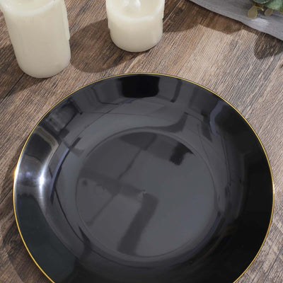 Black plate with gold rim on wooden surface, surrounded by candles.