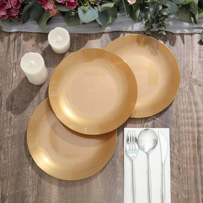 Set of three elegant gold rimmed plates on a rustic wooden table.