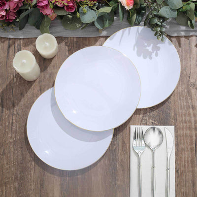 Elegant white dinner plates with gold trim on rustic wooden table.