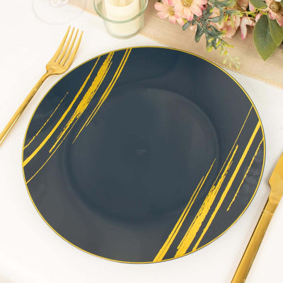 Elegant navy plate with gold brushstroke design on a table setting.