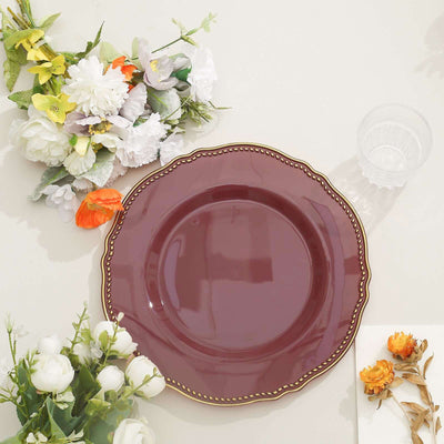 Elegant burgundy plate surrounded by floral arrangements and a glass