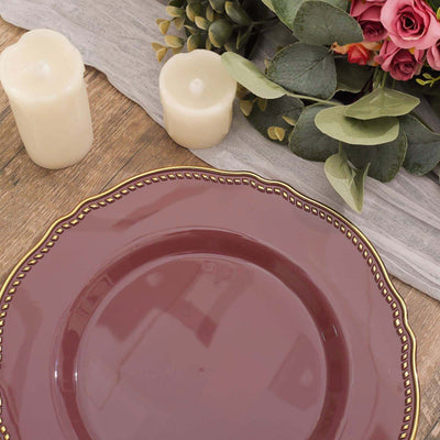 Burgundy decorative plate with gold trim on a rustic wooden table