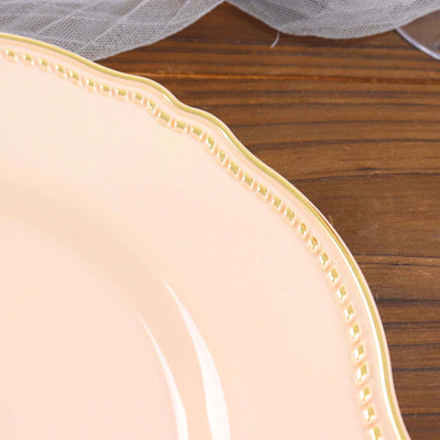 Elegant pink plate with a gold rim detail on a wooden surface.