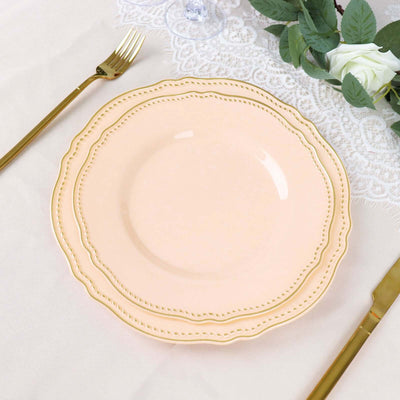 Peach decorative plate with gold trim on a table setting.