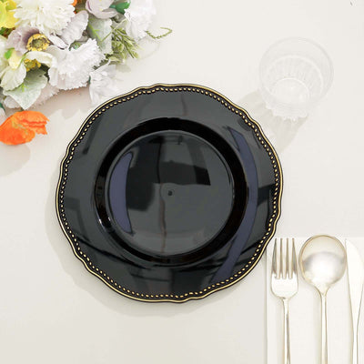 Black decorative plate with gold trim on a table setting.