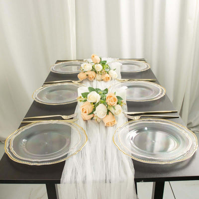 Elegant table setting with clear plates and floral centerpiece.