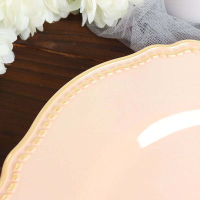 Elegant pink decorative plate with gold trim on a wooden surface.