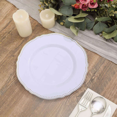 Elegant white plate with gold trim on a rustic wooden table setting.