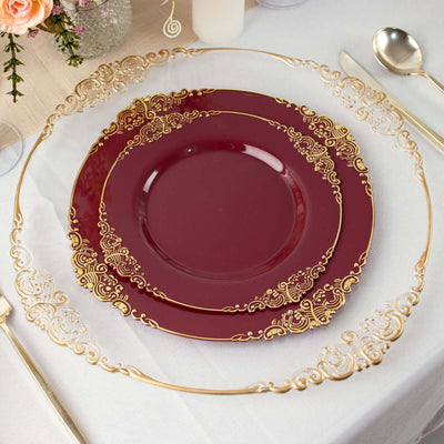 Elegant burgundy dinner plates with gold embellishments on a table setting.